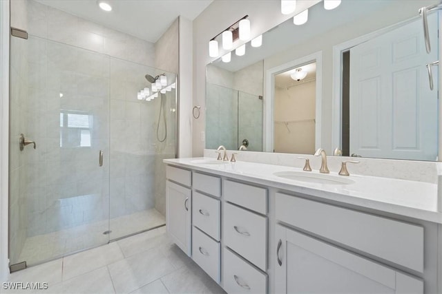 bathroom featuring tile patterned floors, vanity, and a shower with shower door