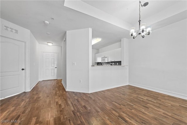 interior space featuring dark hardwood / wood-style flooring and a notable chandelier