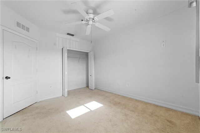 unfurnished bedroom with ceiling fan, a closet, and light colored carpet