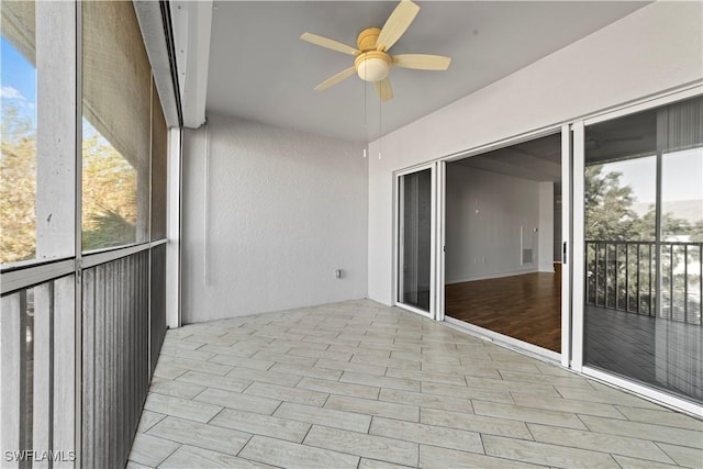 unfurnished sunroom featuring plenty of natural light and ceiling fan