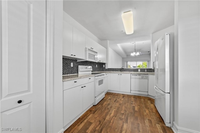 kitchen with white cabinets, dark hardwood / wood-style flooring, white appliances, and a notable chandelier