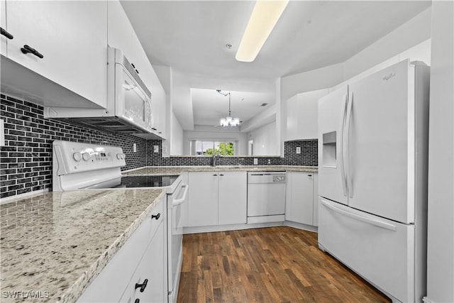 kitchen featuring white appliances, dark wood-type flooring, white cabinets, tasteful backsplash, and decorative light fixtures