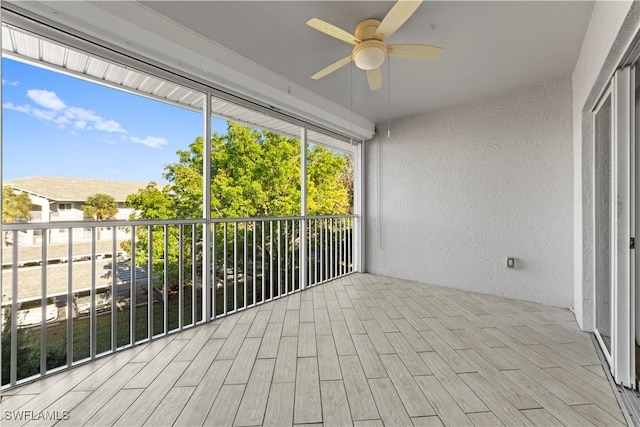 unfurnished sunroom featuring ceiling fan