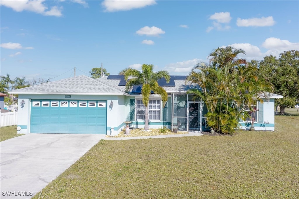 ranch-style home featuring solar panels, a garage, and a front yard