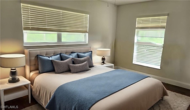 bedroom featuring dark hardwood / wood-style flooring and multiple windows