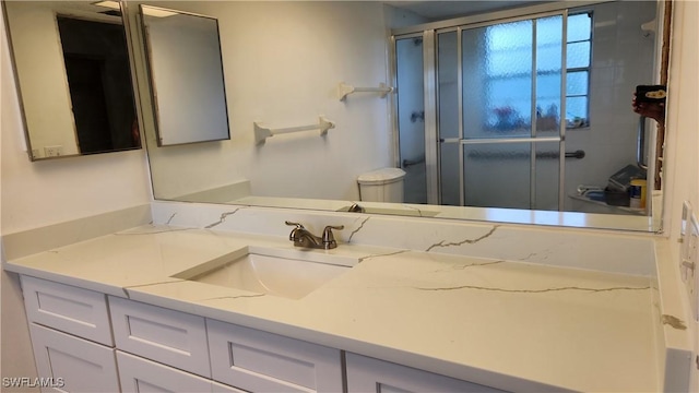 bathroom with vanity and a shower with door