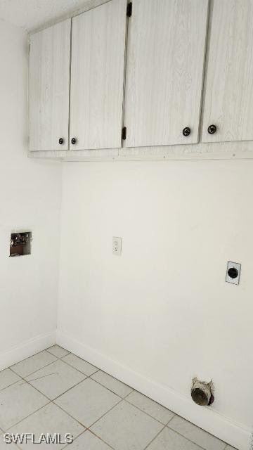 washroom featuring cabinets, light tile patterned floors, and hookup for an electric dryer