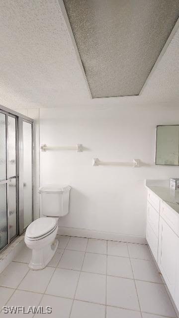 bathroom with tile patterned flooring, a shower with door, and a textured ceiling