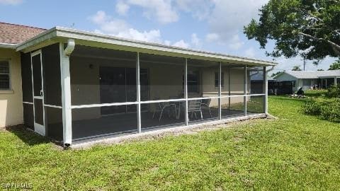 view of home's exterior with a sunroom and a yard