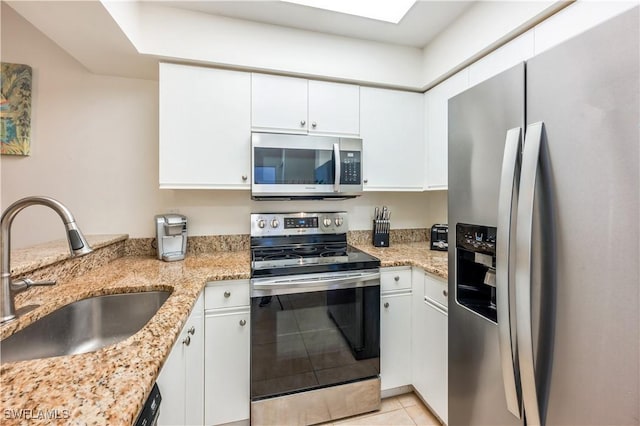 kitchen featuring light stone countertops, sink, white cabinetry, and stainless steel appliances