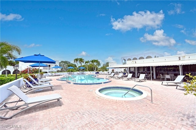 view of swimming pool featuring a patio and a hot tub