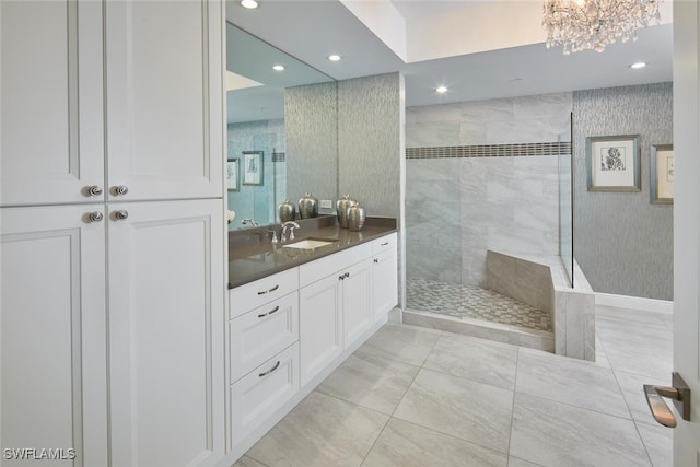 bathroom with vanity, a notable chandelier, and tiled shower