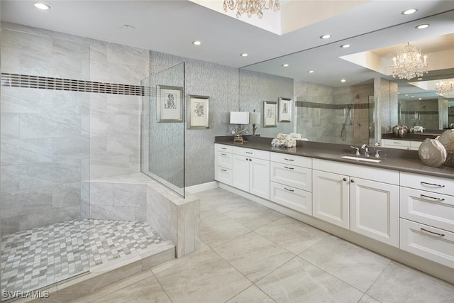 bathroom with a chandelier, vanity, and tiled shower