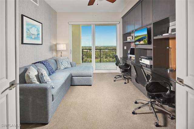 carpeted office space featuring ceiling fan