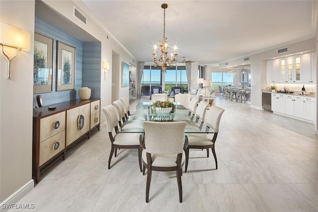 dining area with an inviting chandelier and crown molding