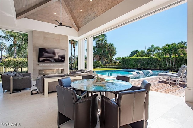 view of patio / terrace featuring ceiling fan, a fenced in pool, and a fireplace