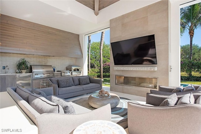 living room featuring a tile fireplace and sink