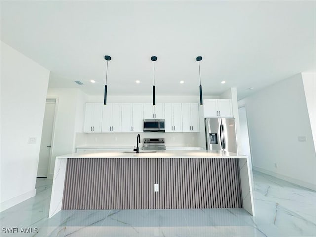 kitchen with a large island, white cabinetry, hanging light fixtures, and appliances with stainless steel finishes