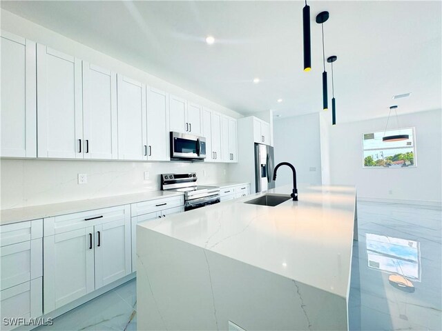 kitchen with pendant lighting, white cabinetry, sink, and stainless steel appliances