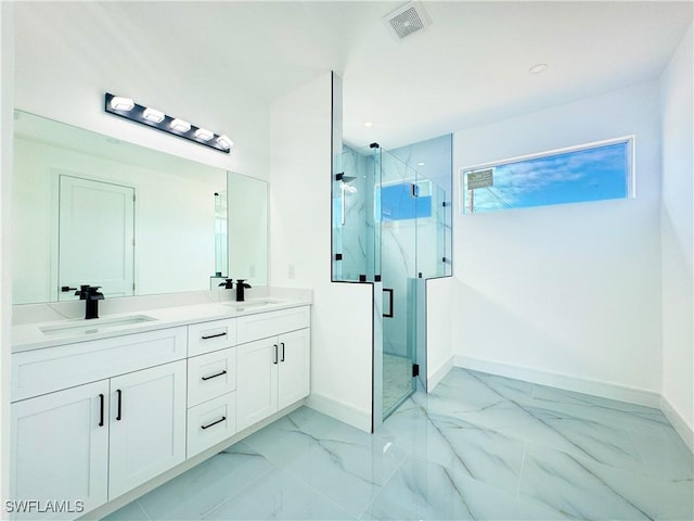 bathroom featuring a shower with door and vanity