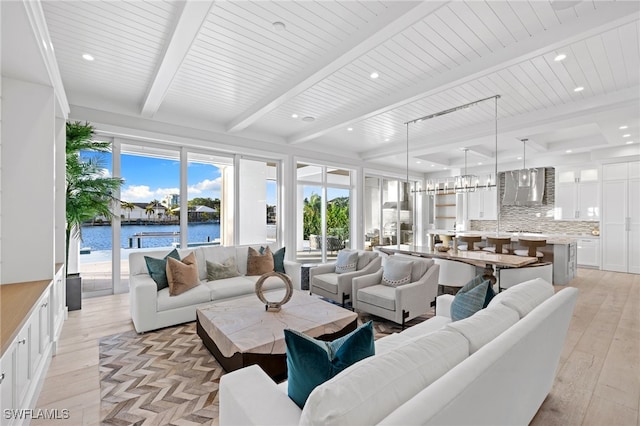 living room featuring light hardwood / wood-style floors, a water view, wooden ceiling, and beam ceiling