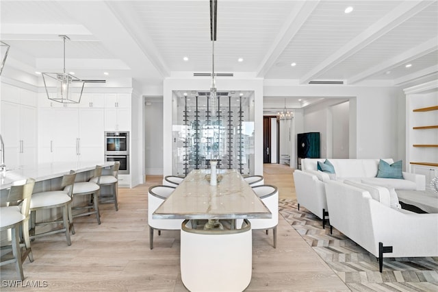 dining area with light hardwood / wood-style flooring and beamed ceiling