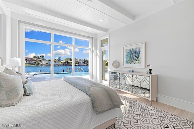 bedroom featuring beam ceiling, access to outside, light hardwood / wood-style flooring, and a water view