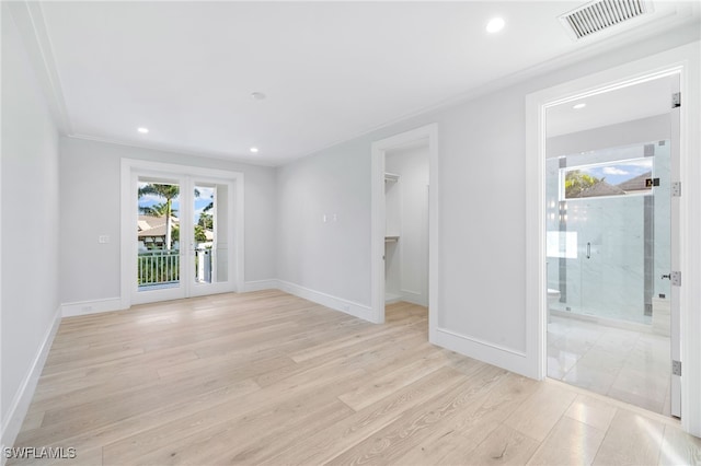 unfurnished room featuring light hardwood / wood-style floors and ornamental molding