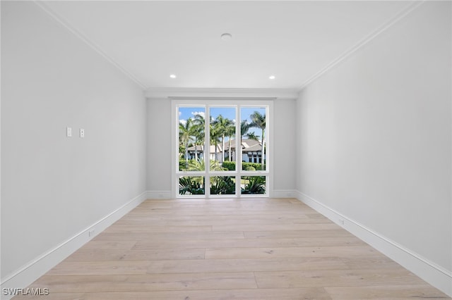 empty room featuring light hardwood / wood-style floors and crown molding