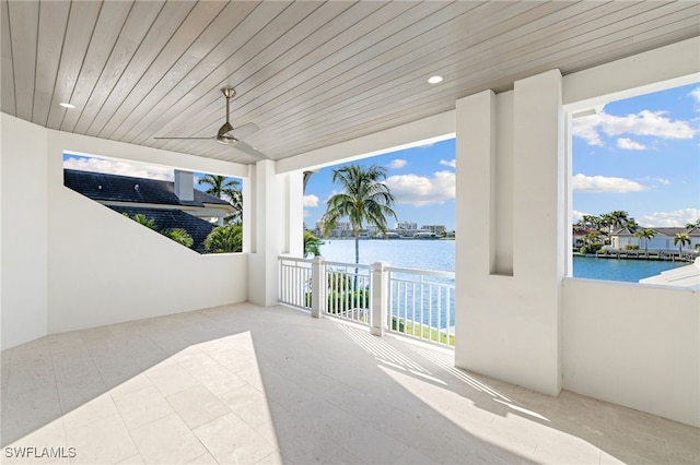 view of patio featuring ceiling fan, a balcony, and a water view