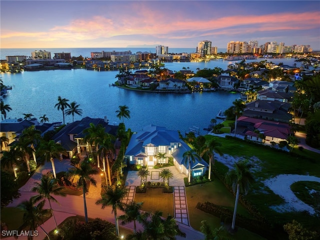 aerial view at dusk featuring a water view