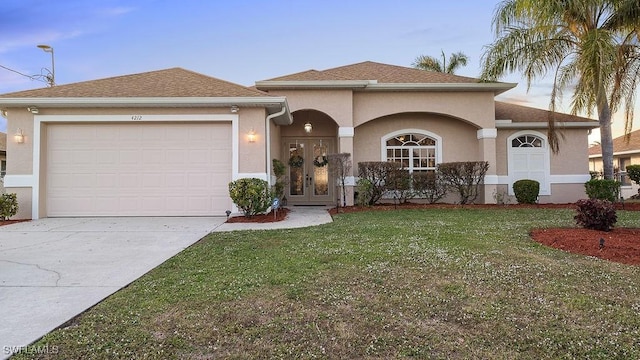 view of front of property with french doors, a yard, and a garage