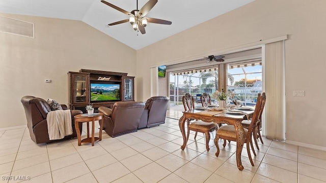 dining space with ceiling fan, light tile patterned flooring, and vaulted ceiling