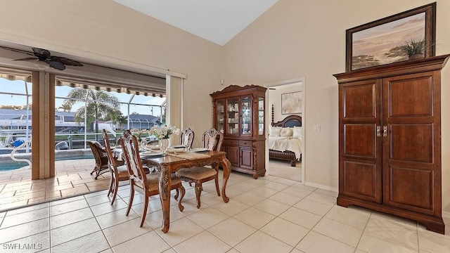 dining space with ceiling fan, light tile patterned floors, and lofted ceiling