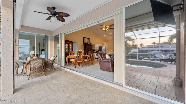 patio terrace at dusk with a lanai and ceiling fan