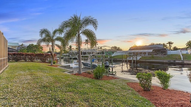 dock area featuring a water view and a yard