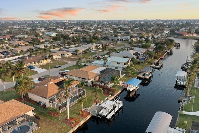 aerial view at dusk featuring a water view