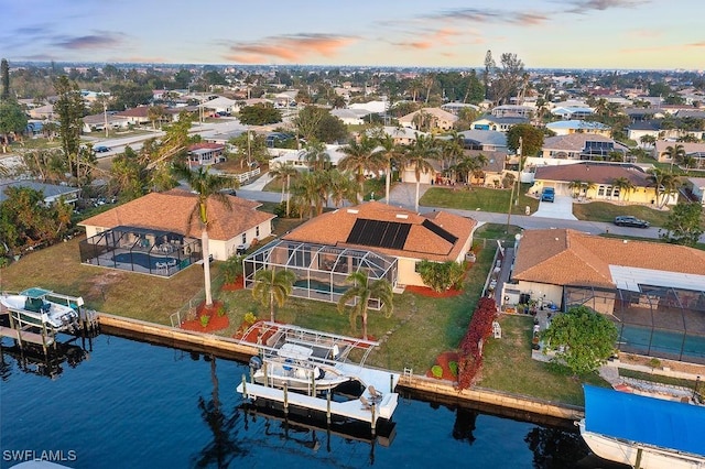 aerial view at dusk featuring a water view