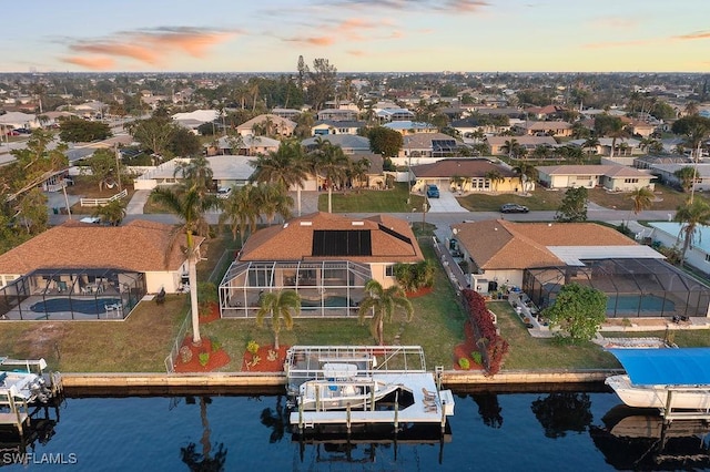 aerial view at dusk featuring a water view