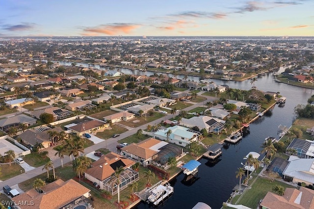 aerial view at dusk featuring a water view