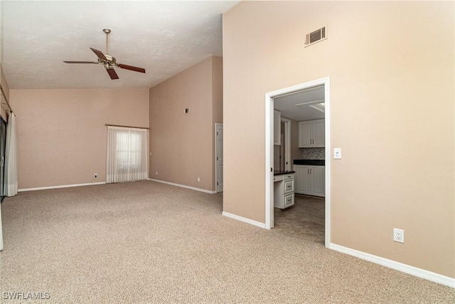 interior space with a textured ceiling, ceiling fan, light carpet, and high vaulted ceiling