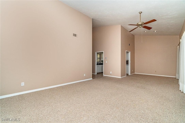 empty room with carpet flooring, ceiling fan, and high vaulted ceiling