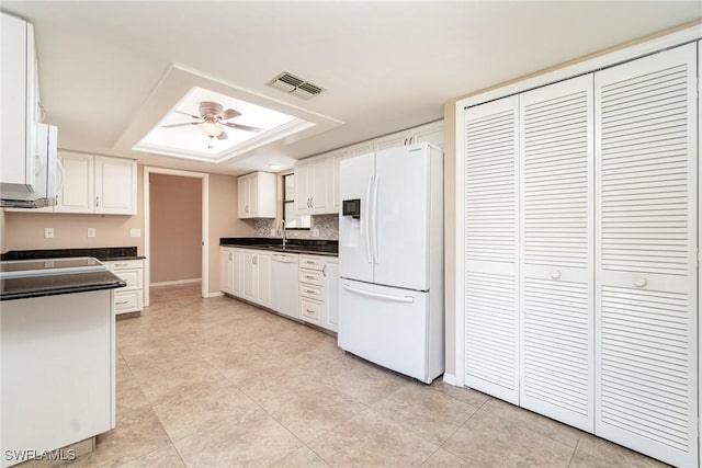 kitchen featuring white appliances, ceiling fan, sink, white cabinetry, and light tile patterned flooring