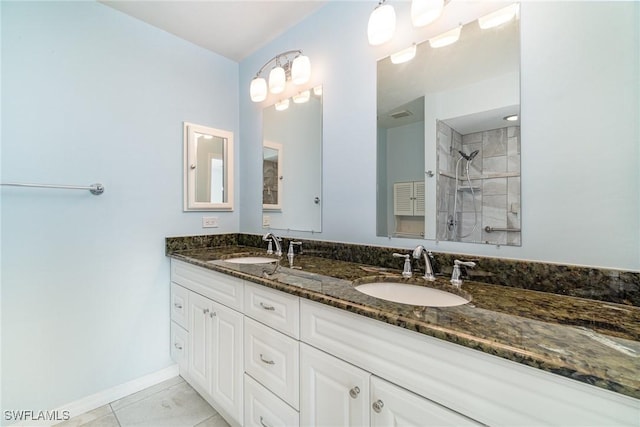 bathroom featuring a tile shower and vanity