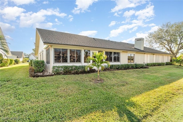 rear view of house featuring a yard