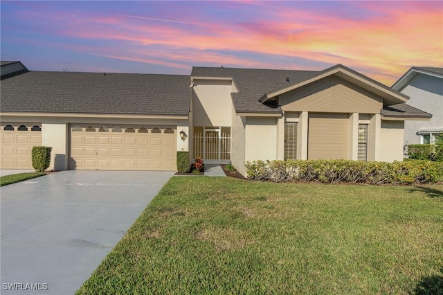 single story home featuring a garage and a yard