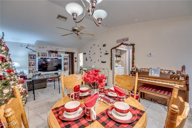 dining area featuring vaulted ceiling, light tile patterned floors, and ceiling fan with notable chandelier