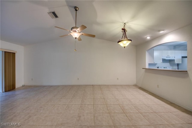 tiled empty room with vaulted ceiling and ceiling fan