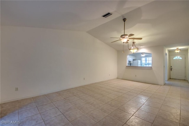 spare room featuring vaulted ceiling, ceiling fan, and light tile patterned flooring