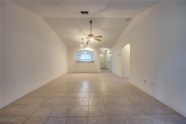 empty room featuring ceiling fan, light tile patterned floors, and lofted ceiling